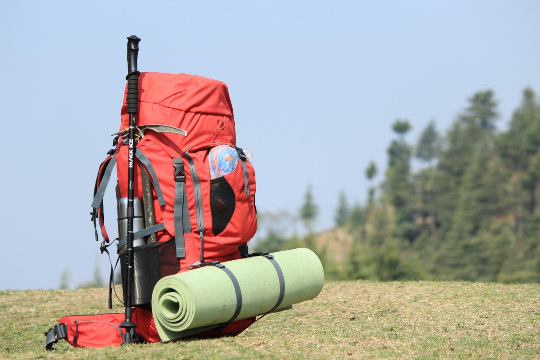 Red day-hike daypack with trail essentials laid out for a Colorado morning.